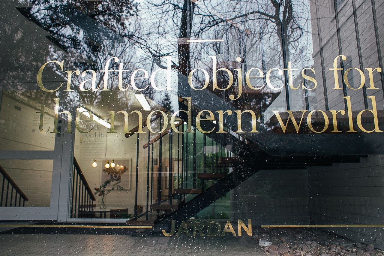 Crafting Captivating Headlines: Your awesome post title goes here Through window of modern house with creative baby pink signboard with the phrase werbung, die sichtbar macht on reflecting glass facade and staircase inside building located on street